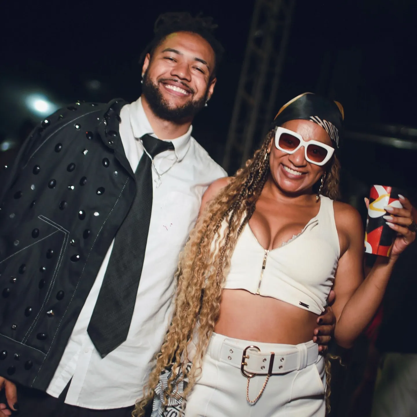 Arape Malik de terno e gravata no AFROPUNK, ao lado de uma convidada